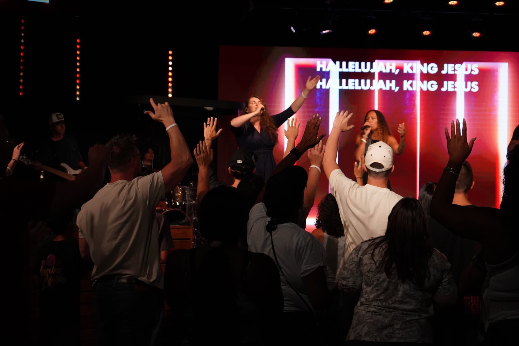 The Canvas Church congregation worshiping with hands raised